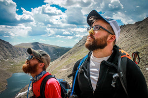 Two men on a hike wearing Nöz sunscreen looking up at the sky